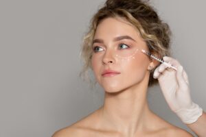 Woman receiving dermal filler injections under her eye, with a diagram showing her hollow under eye